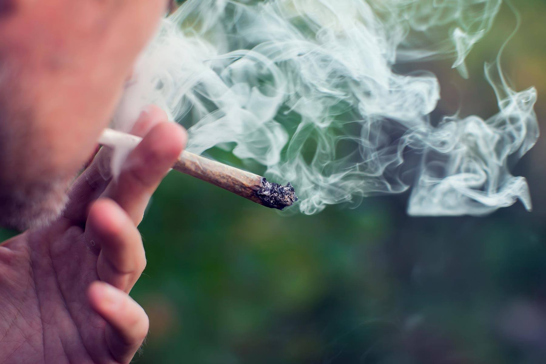 Closeup of a Man Smoking a Lit Cannabis Joint