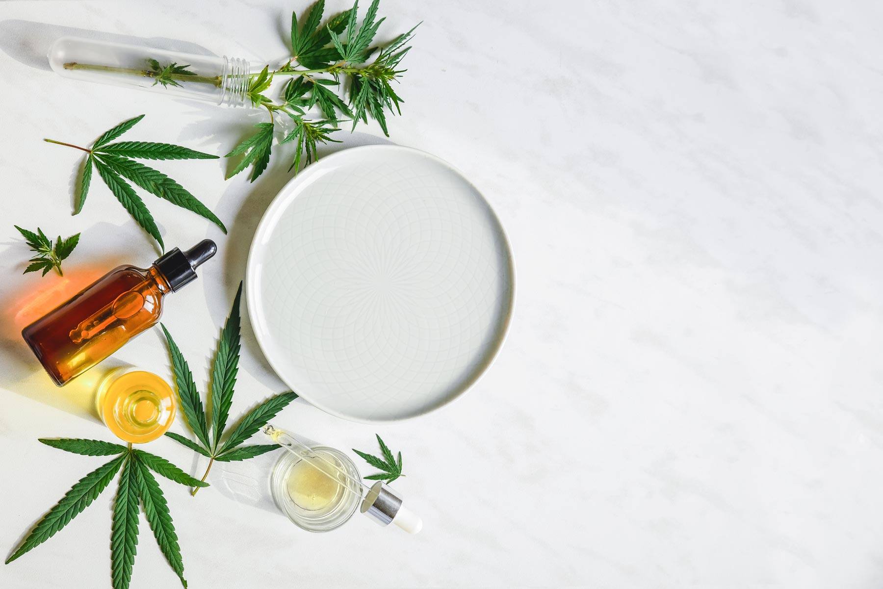 Marijuana Leaves Tinctures and Oils on a White Countertop