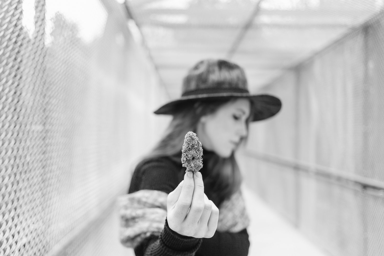 1 woman wearing hat and scarf holding cannabis flower